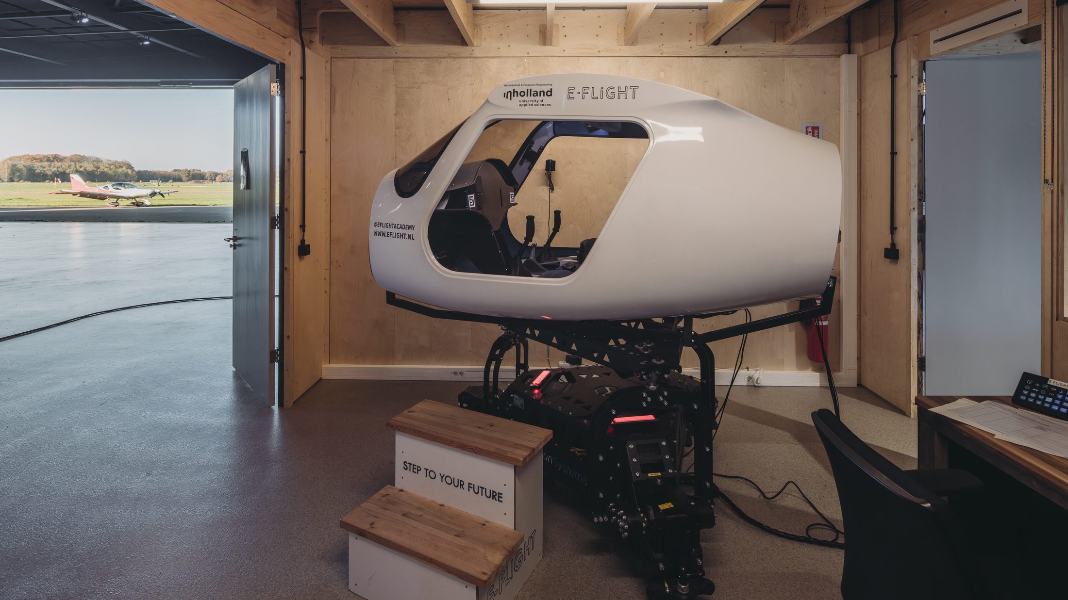 The E-Flight Velis Simulator in E-Deck, with the hangar door open to the airfield at Teuge